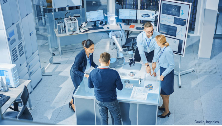 Vier Personen in einer technischen Laborumgebung, die gemeinsam diskutieren und Lösungen für die Arbeitswelt von Morgen erarbeiten.