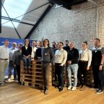 Gruppenbild von den Teilnehmenden am Konsortialtreffen auf einem Palettenstapel